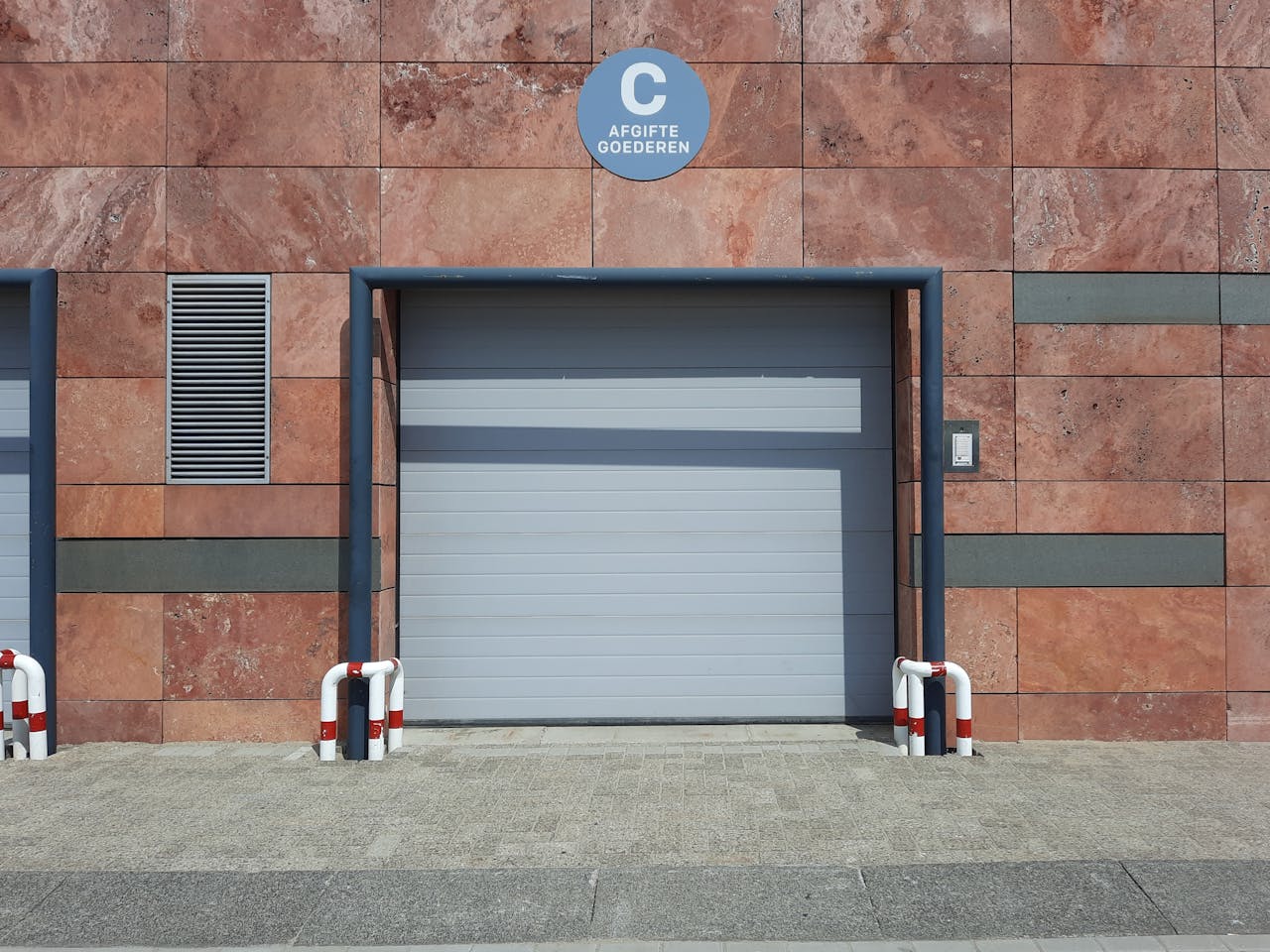 Front view of a modern urban garage entrance with clear signage in natural light.